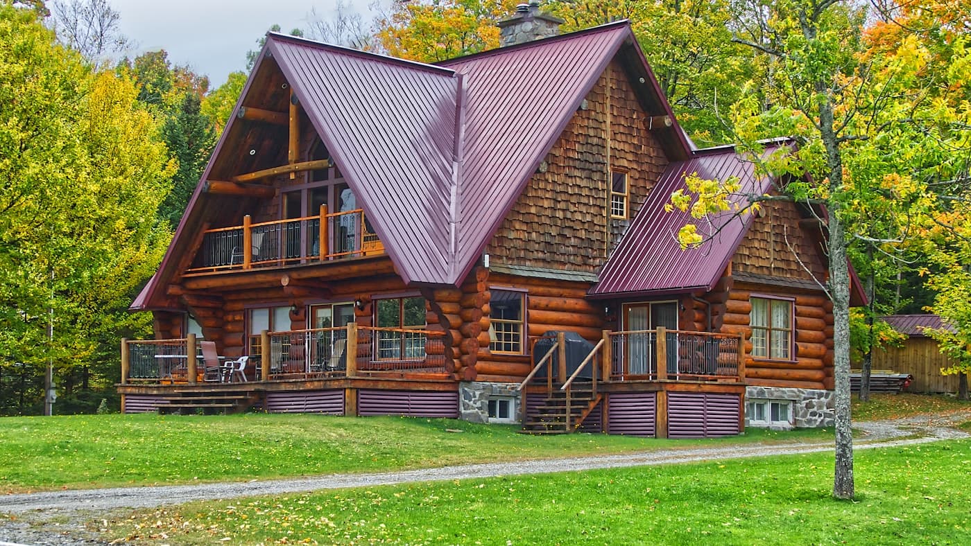 A home exterior framed by a green lawn and trees